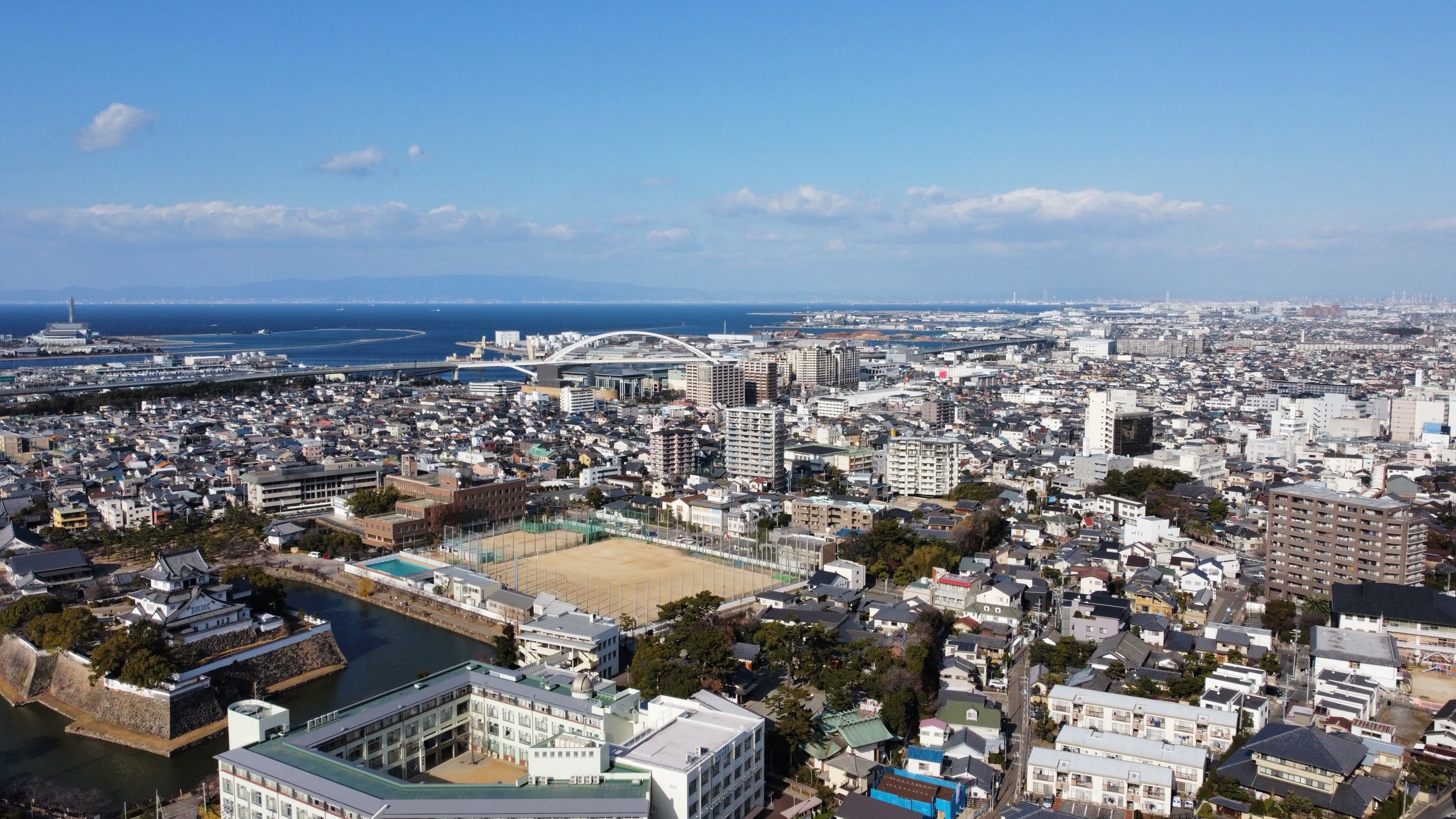 岸和田城と大阪湾を見渡す岸和田市街地の空撮写真
